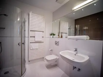 a white bathroom with a sink and a toilet at Dom Profesorski im. Stanisława Pigonia in Kraków