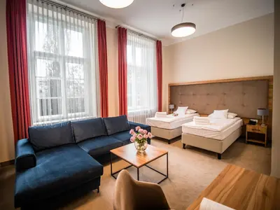 a living room with a blue couch and a table at Dom Profesorski im. Stanisława Pigonia in Kraków