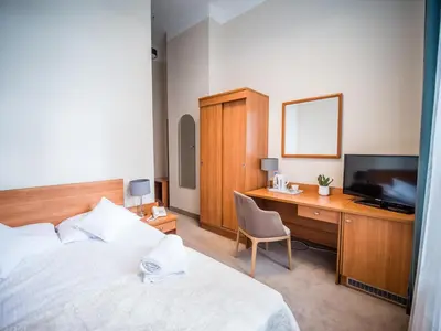 a bedroom with a bed and a desk and a television at Dom Profesorski im. Stanisława Pigonia in Kraków