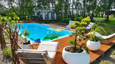 a swimming pool with potted plants on a wooden deck at Domek Niebieskie Marzenie in Chrzanów