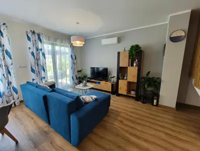 a living room with a blue couch and a tv at Domek Niebieskie Marzenie in Chrzanów