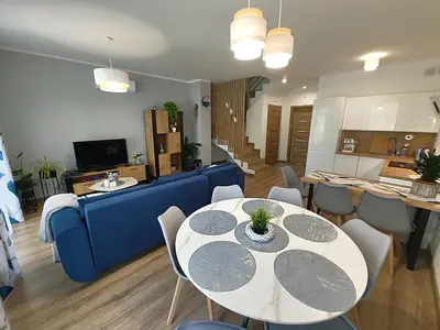 a living room with a blue couch and a table and chairs at Domek Niebieskie Marzenie in Chrzanów