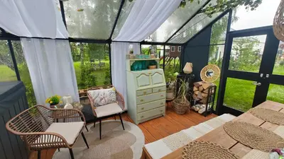 a conservatory with chairs and tables and a room with windows at Domek Niebieskie Marzenie in Chrzanów