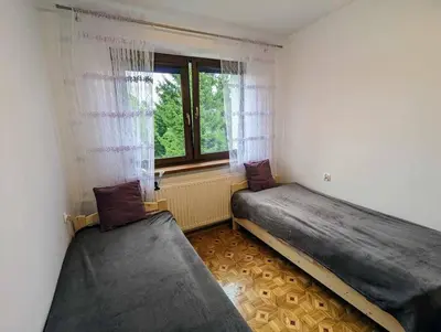 two beds in a room with a window at Guest House close to Molo Resort in Osiek