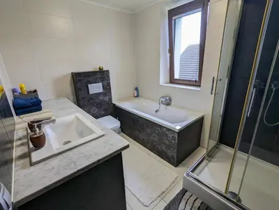 a bathroom with a sink and a tub and a toilet at Guest House close to Molo Resort in Osiek