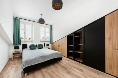 a bedroom with a bed and a large closet at WAWELOFT APARTMENT in Kraków