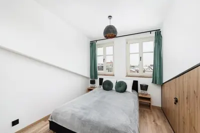 a bedroom with a large bed with green curtains at WAWELOFT APARTMENT in Kraków