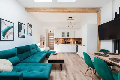a living room with a blue couch and a table at WAWELOFT APARTMENT in Kraków