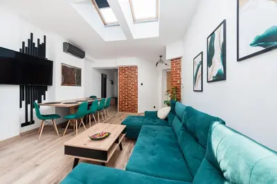 a living room with a green couch and a table at WAWELOFT APARTMENT in Kraków