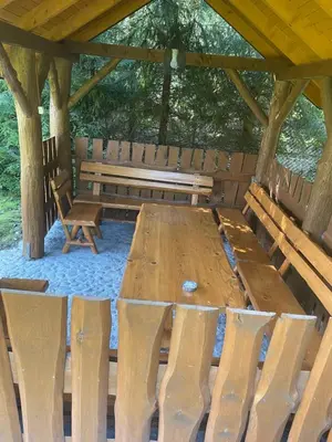 a wooden table and benches in a pavilion at Zakątek przy lesie in Łętowice