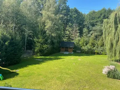 a garden with a small cabin in the middle of it at Zakątek przy lesie in Łętowice