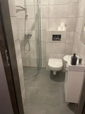 a bathroom with a shower and a toilet and a sink at Zakątek przy lesie in Łętowice