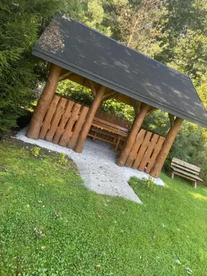 a picnic shelter with two benches in the grass at Zakątek przy lesie in Łętowice