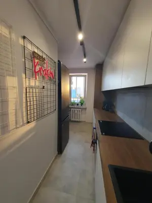 a hallway of a kitchen with a counter and a door at Apartamenty Cześć Kraków in Kraków