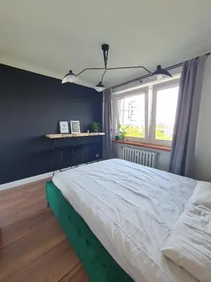 a bedroom with a large bed and a window at Apartamenty Cześć Kraków in Kraków