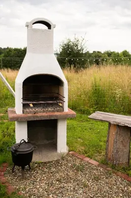 an outdoor oven with a pot sitting next to a bench at Biwak u Gazdy in Gosprzydowa