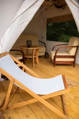a chair in a living room with a tent at Biwak u Gazdy in Gosprzydowa