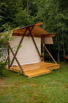 a gazebo with a wooden deck in the grass at Biwak u Gazdy in Gosprzydowa