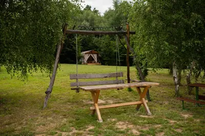 a wooden swing in a park with a tent at Biwak u Gazdy in Gosprzydowa