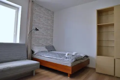 a bedroom with a bed and a brick wall at Ring Apartments - Kraków in Kraków