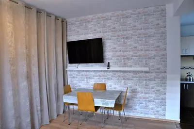 a dining room with a brick wall and a table and chairs at Ring Apartments - Kraków in Kraków