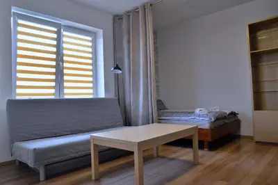 a room with a table and a bed and a window at Ring Apartments - Kraków in Kraków
