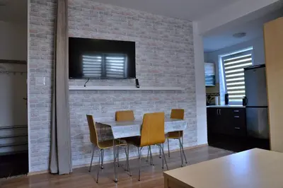 a dining room with a brick wall and a table and chairs at Ring Apartments - Kraków in Kraków