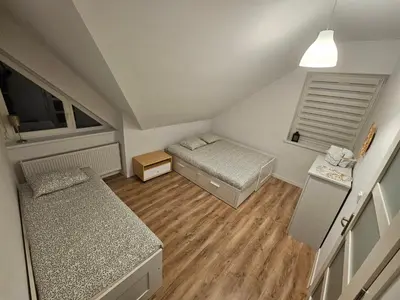 a small room with two beds and a window at Dom na Partykowie in Budzów
