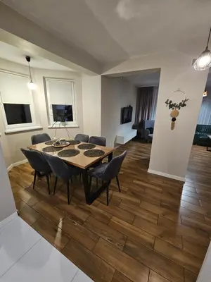a dining room table and chairs in a living room at Dom na Partykowie in Budzów