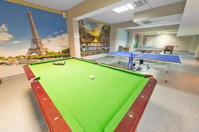 a billiard room with a pool table and the eiffel tower at Hotel Olivia Medical SPA in Skomielna Czarna
