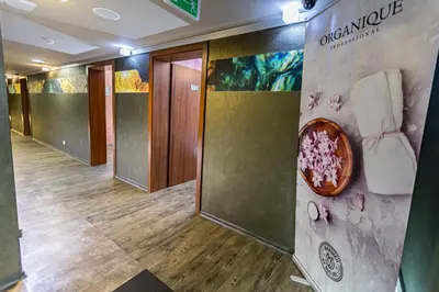 a hallway of a hotel with doors and a sign on the wall at Hotel Olivia Medical SPA in Skomielna Czarna