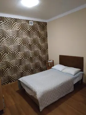 a bedroom with two beds and a patterned wall at FEIDUM quarters flat in Kraków