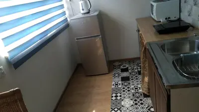a small kitchen with a sink and a refrigerator at FEIDUM quarters flat in Kraków