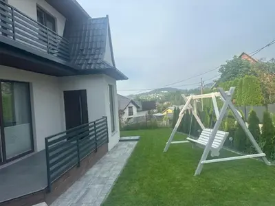 a swing in a yard next to a house at Willa Na Bystrej - Całoroczny dom na wynajem in Rabka-Zdroj