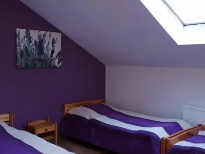 a bedroom with two beds with purple walls at Amla in Biadoliny Radłowskie