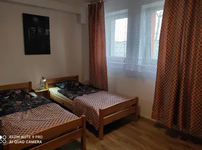a bedroom with two beds and a window with curtains at Amla in Biadoliny Radłowskie