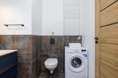 a bathroom with a toilet and a washing machine at Beautiful Apartment Klimeckiego with balcony by Noclegi Renters in Kraków
