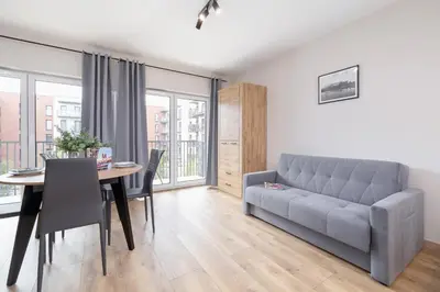 a living room with a couch and a table at Beautiful Apartment Klimeckiego with balcony by Noclegi Renters in Kraków