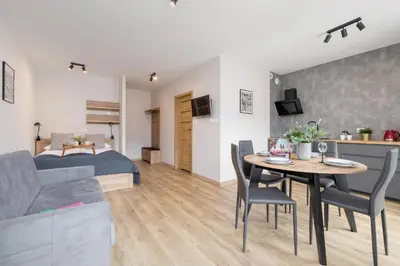 a bedroom and a living room with a bed and a table at Beautiful Apartment Klimeckiego with balcony by Noclegi Renters in Kraków