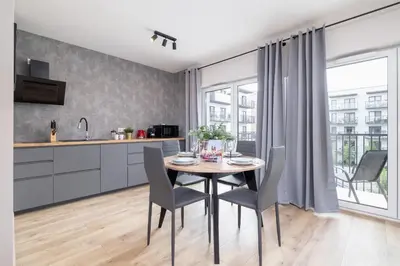 a kitchen and dining room with a table and chairs at Beautiful Apartment Klimeckiego with balcony by Noclegi Renters in Kraków
