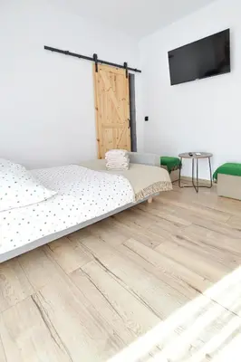 a bedroom with a bed and a wooden floor at Miętowe Zacisze Zator in Laskowa