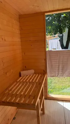 a wooden sauna with a bench next to a window at Mały biały domek Wadowice SPA jacuzzi sauna Gorzen blisko Wadowic in Gorzeń Dolny