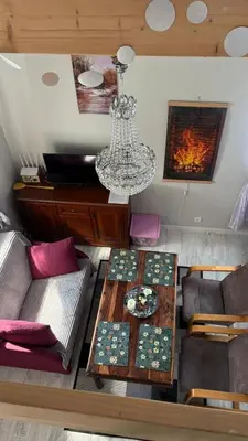 a living room with a table and a chandelier at Mały biały domek Wadowice SPA jacuzzi sauna Gorzen blisko Wadowic in Gorzeń Dolny