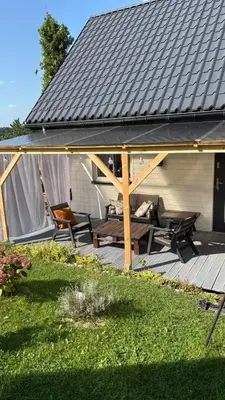 a pavilion with a table and chairs on a deck at Mały biały domek Wadowice SPA jacuzzi sauna Gorzen blisko Wadowic in Gorzeń Dolny