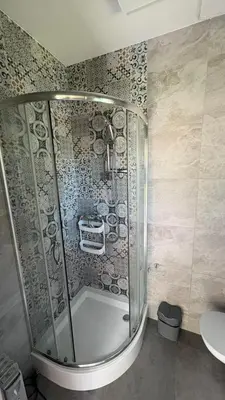 a shower with a glass door in a bathroom at Mały biały domek Wadowice SPA jacuzzi sauna Gorzen blisko Wadowic in Gorzeń Dolny