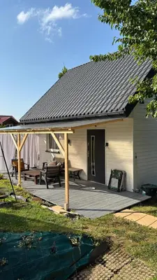 a house with a deck with a roof at Mały biały domek Wadowice SPA jacuzzi sauna Gorzen blisko Wadowic in Gorzeń Dolny