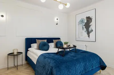 a bedroom with a blue bed with a blue blanket at Elegant Studio Szpakowa 10 with 2 Parking Spaces & Terrace by Noclegi Renters in Kraków