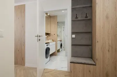 a white kitchen with a washer and dryer at Elegant Studio Szpakowa 10 with 2 Parking Spaces & Terrace by Noclegi Renters in Kraków