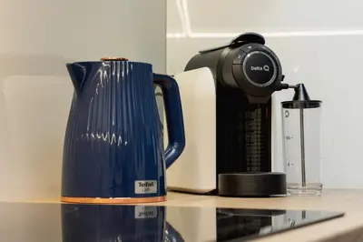 a blue jug sitting on a counter next to a coffee maker at Elegant Studio Szpakowa 10 with 2 Parking Spaces & Terrace by Noclegi Renters in Kraków
