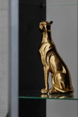 a gold cat statue sitting on a glass shelf at Elegant Studio Szpakowa 10 with 2 Parking Spaces & Terrace by Noclegi Renters in Kraków